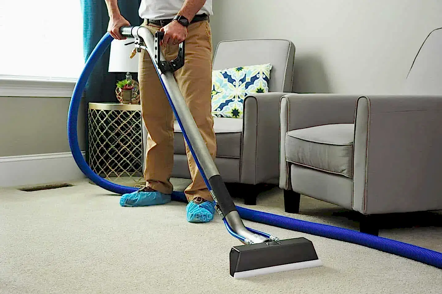 Vacuum cleaner cleaning carpet in a modern living room for deep cleaning service.